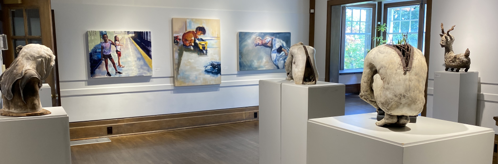 Gallery interior with painting on the wall and sculptures on pedestals