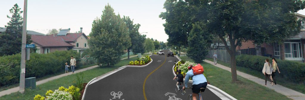 An artistic rendering of Ingleton Boulevard showing a driver's view. On the road are two cyclists and arrows on the road indicating the road is to be shared with cyclists. People are walking on the sidewalks and a chicane is depicted on the left side of the road and two cars are seen in the distance.