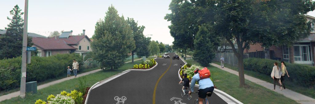 An artistic rendering of Ingleton Boulevard showing a driver's view. On the road are two cyclists and arrows on the road indicating the road is to be shared with cyclists. People are walking on the sidewalks and a chicane is depicted on the left side of the road and two cars are seen in the distance.