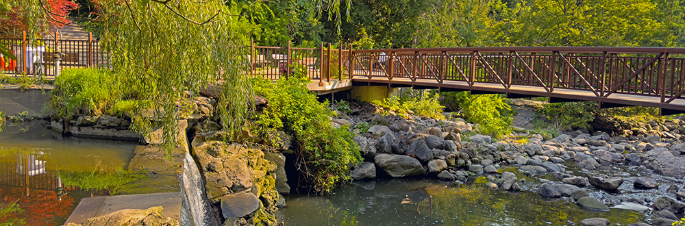photography area with waterfalls, and bridge over running river at Edwards Gardens
