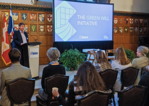 James Nowlan talking to a crowd with a PowerPoint slide that reads The Greenwill Initiative in background.