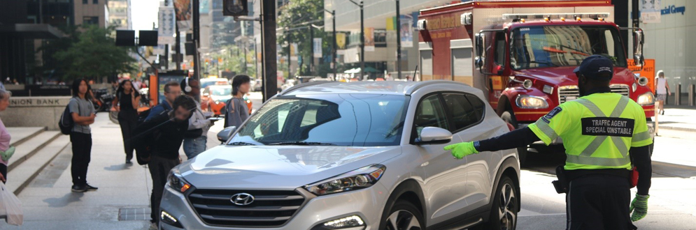 Traffic Agent directs car to make a left turn in an intersection downtown.