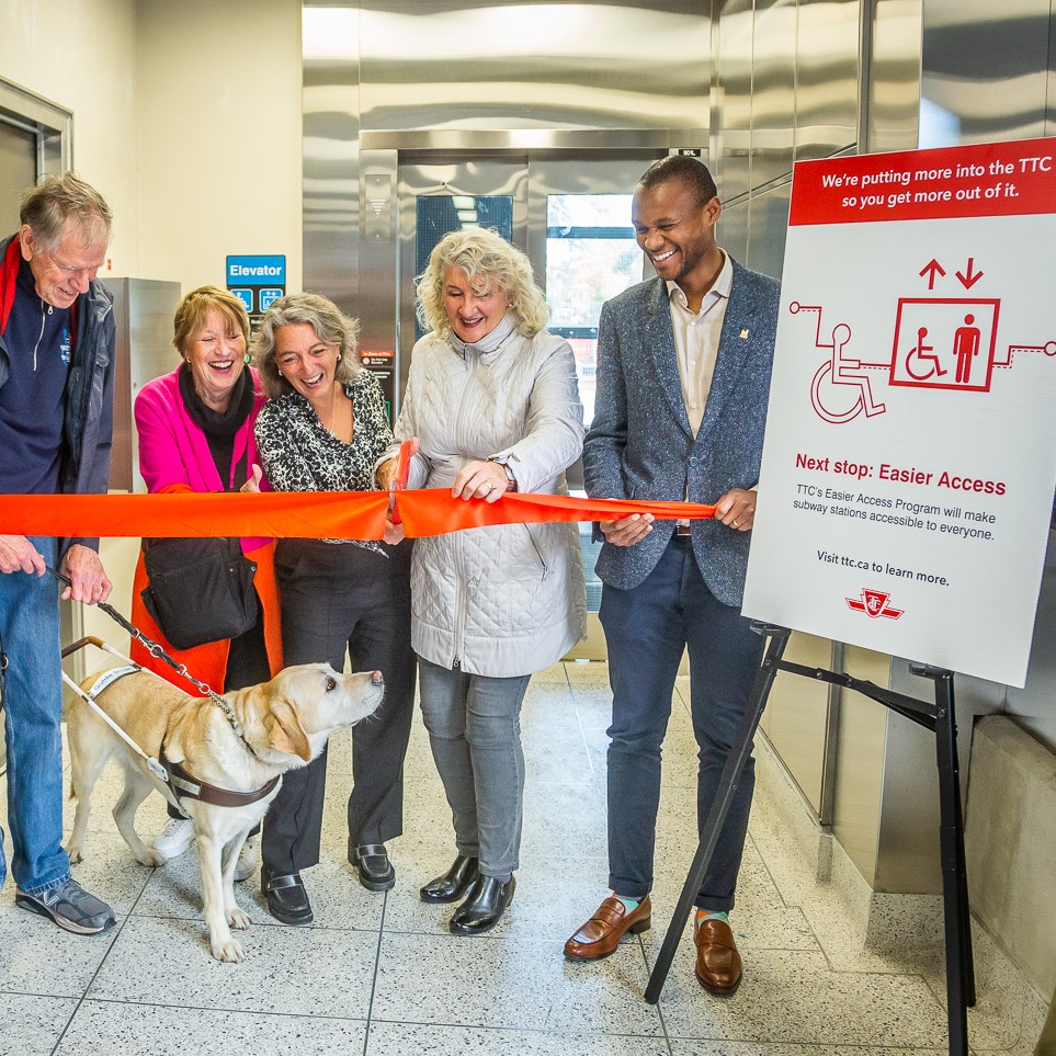Councillor Fletcher and Myers cut ribbon with members of the community when the Donlands elevator opened.
