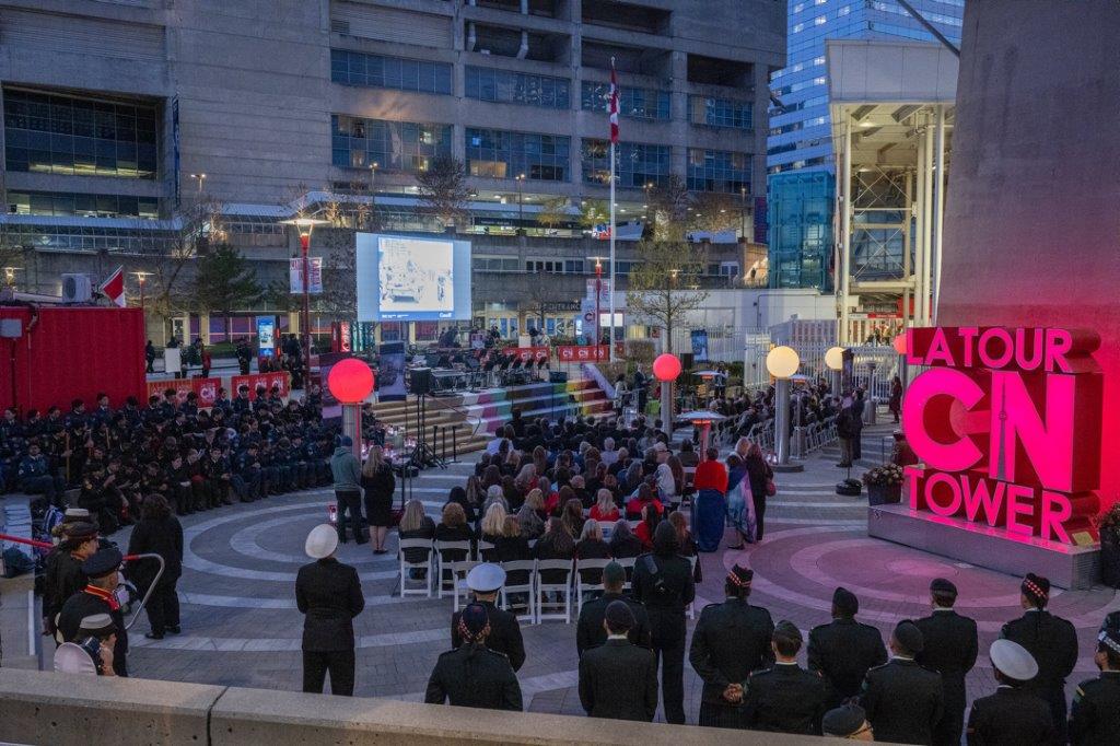 Wide shot of a ceremony at the base of the CN Tower