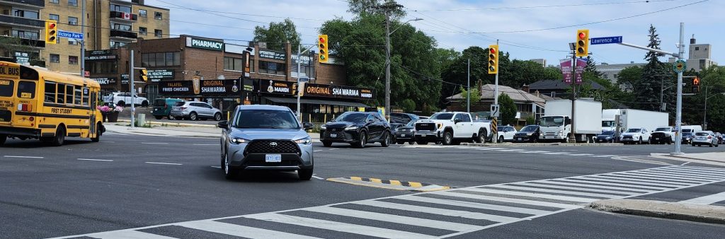 A person driving navigating around a left-turn calming installation at Lawrence Ave E and Victoria Park