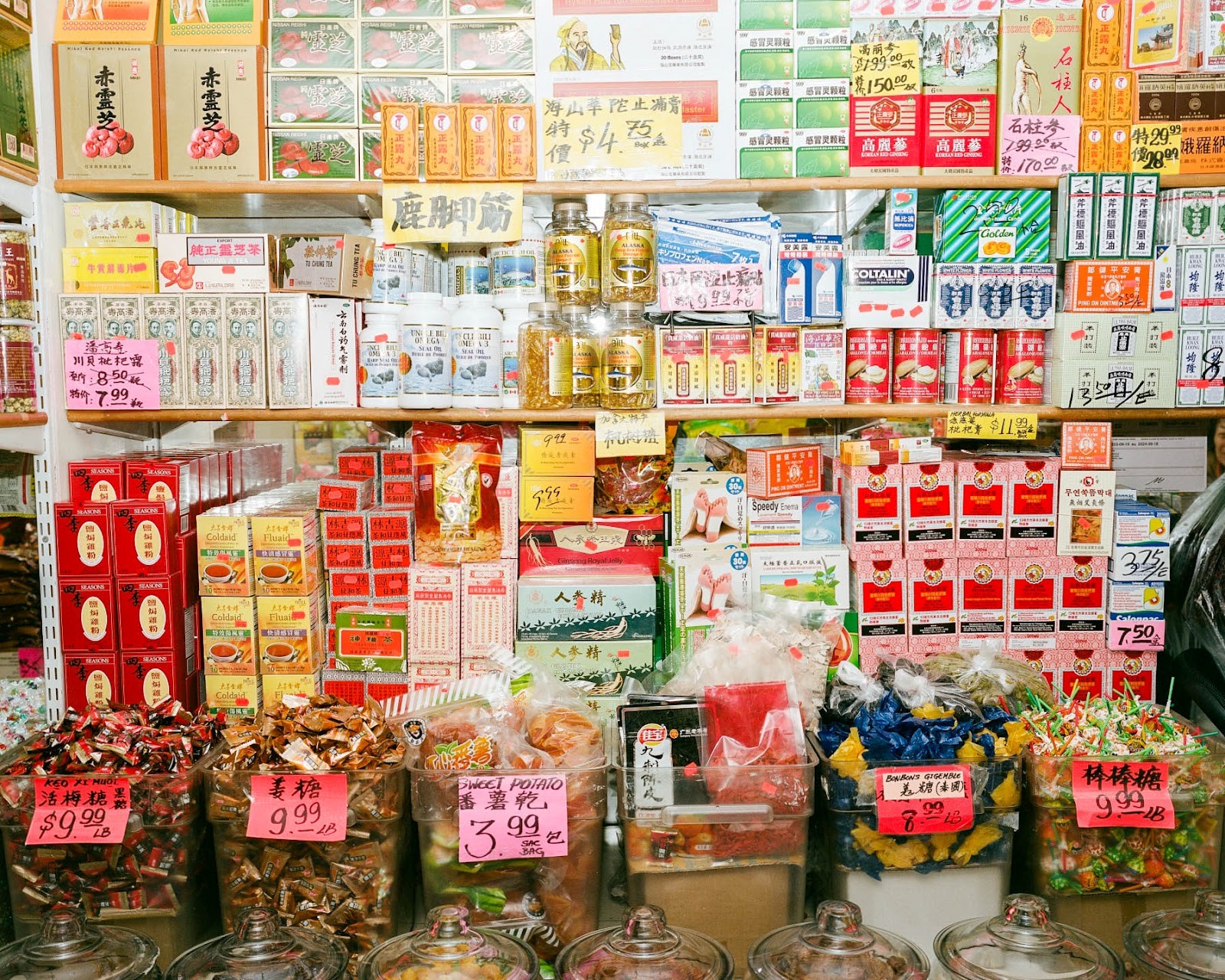 Photograph of a grocery store shelf filled with red and gold items.