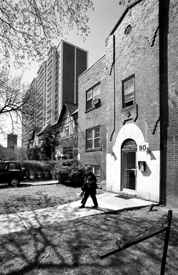 - A woman walks out of a low-rise residential apartment adjacent to a single family house and tall apartment building.