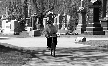 A woman cycles through Mount Pleasant Cemetery.