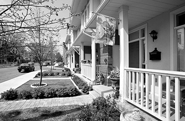 A row of attached residential townhomes with front porches.