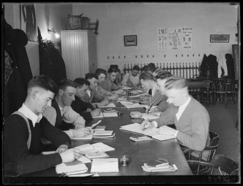 Group of male students working around a table.