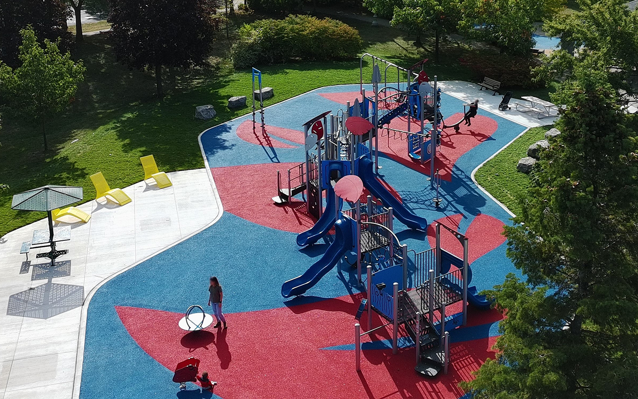 The new playground on a colourful surface with multiple climbing areas, slides and swings.