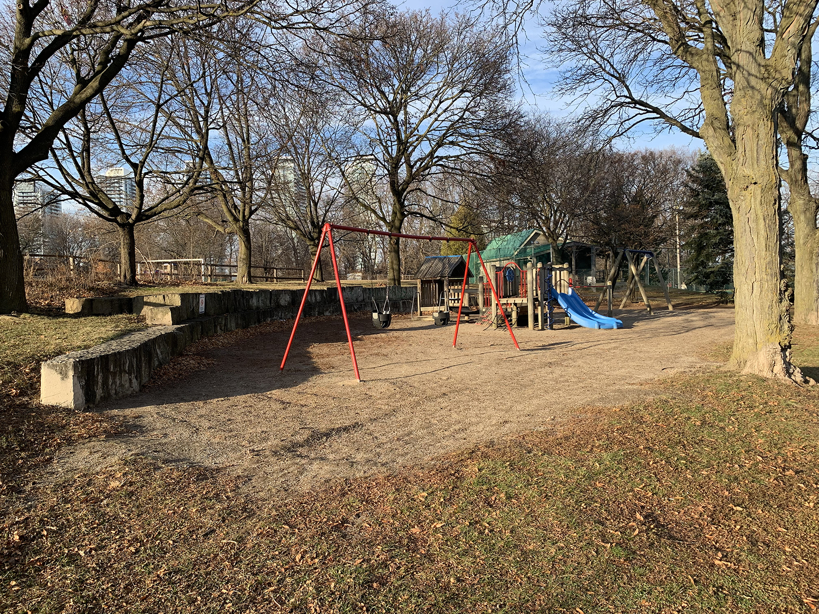 Swings with a wooden play structure in the background.