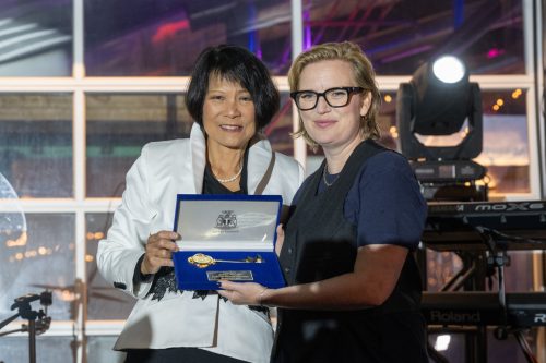 Two persons holding a velvet box with a key in it