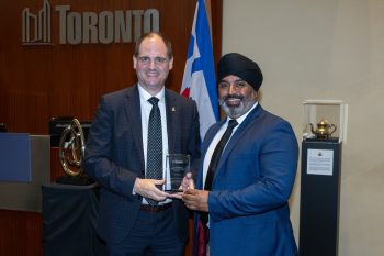 Two people pose for a photo with an award.