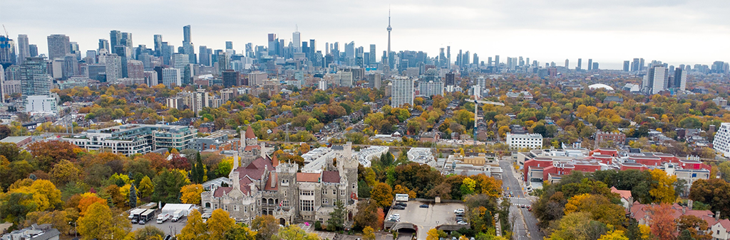 An aerial view of the Toronto skyline with Casa Loma, a castle building in the foreground on an autumn day.