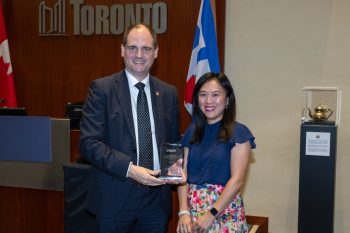 Two people pose for a photo with an award.