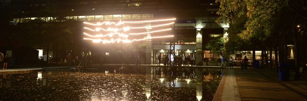 Lines of neon lights over a pool of water at night