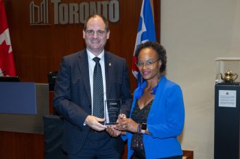 Two people pose for a photo with an award.