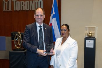 Two people pose for a photo with an award.