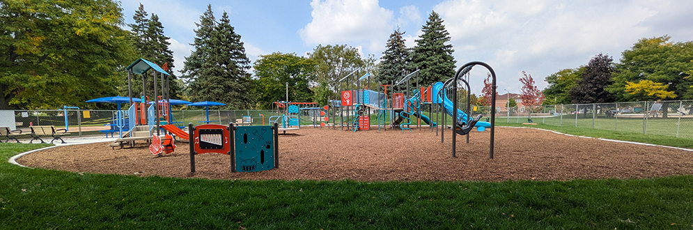 A colourful playground with swings, slides and climbing equipment.