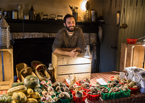 Vendor of food produce in front of historic fireplace