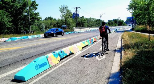 A photo of a painted low wall barrier and a bike lane