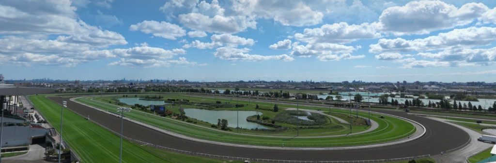 : A race track with a body of water with a city skyline in the background.
