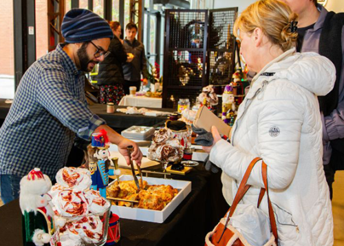 A person shopping at a market table indoors.