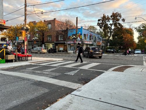 Photo of a street corner with a raised pedestrian crossing
