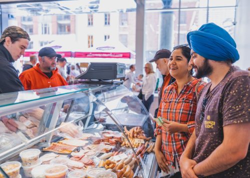 People shopping at a deli counter.