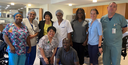 Mayor Chow and a group of long‑term care staff wearing scrubs and uniforms stand together for a photo at Kipling Acres.