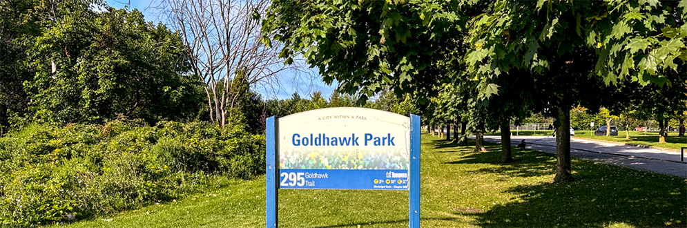 Goldhawk Park sign with trees in the background.