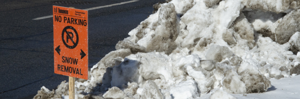 An orange sign indicating not to park due to snow removal