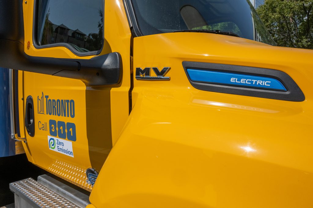 An orange truck cab with the City of Toronto logo and 311 logo.