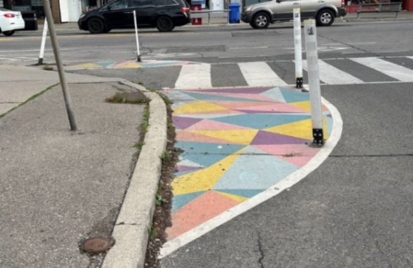 Extended curb with paint and quick-build bollards