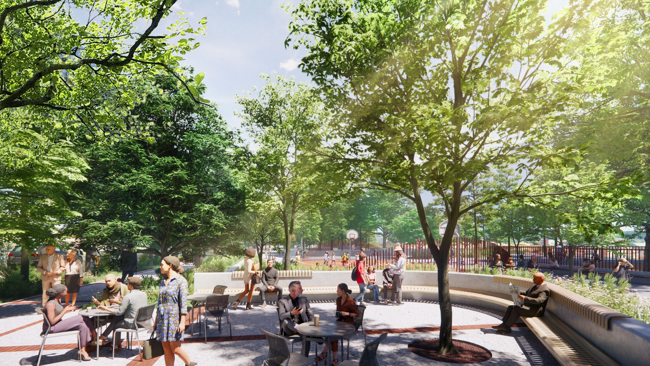 View looking east from the Esplanade showing a landscaped seating plaza with curved benches and trees in the foreground. People are seated and gathering at tables and seating areas. In the background, the playground area is visible behind fencing and planting, creating a connected public space.