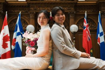 A smiling, recently married couple is sitting in the wedding chamber in Old City Hall.