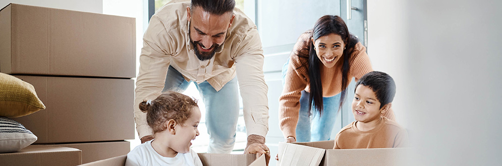 Family in the middle of unpacking with parents playing with kids
