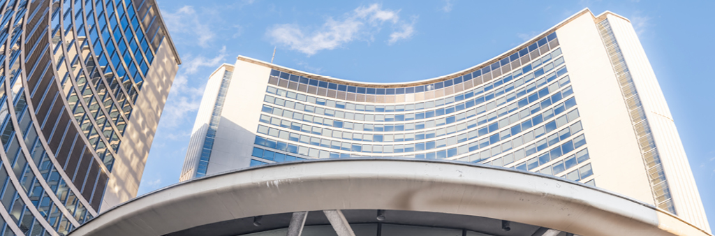 Toronto City Hall towers and rotunda against the sky, looking up from below.