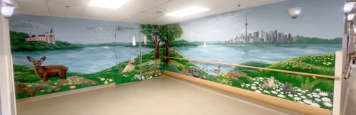 A wide hallway features a large, colourful mural of a peaceful outdoor scene with green fields, flowers, trees, and animals, opening onto a blue lake with sailboats and a city skyline, with the CN Tower in the distance.