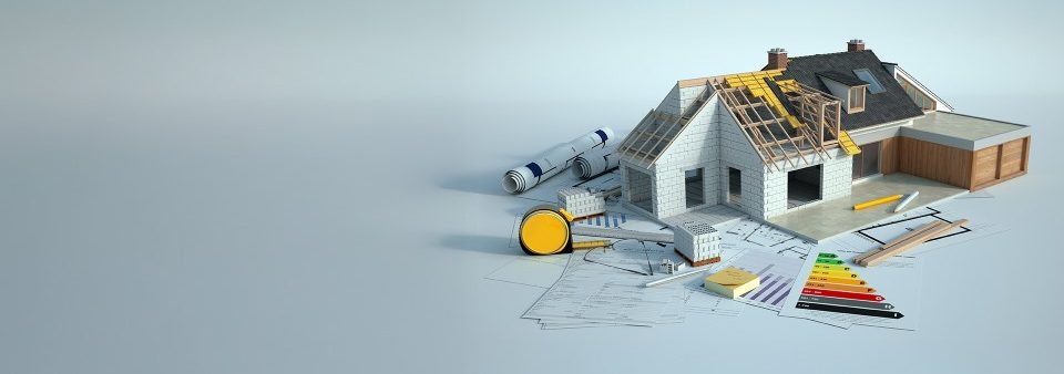 A miniature house surrounded by building tools and plans.
