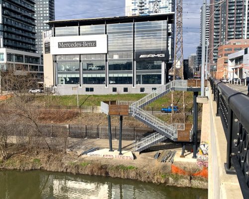 A three-tier staircase with city buildings and road in background