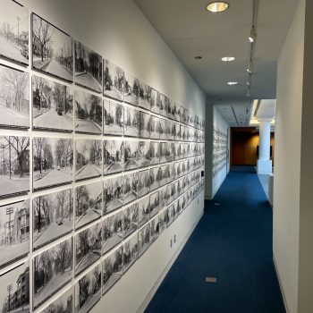 Image depicts close up of archival monochrome photographs on wall