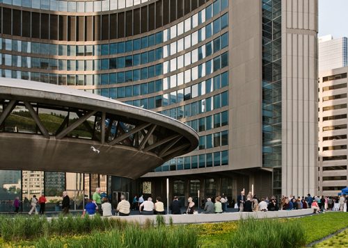 Crowd around City Hall rotunda, tower and garden