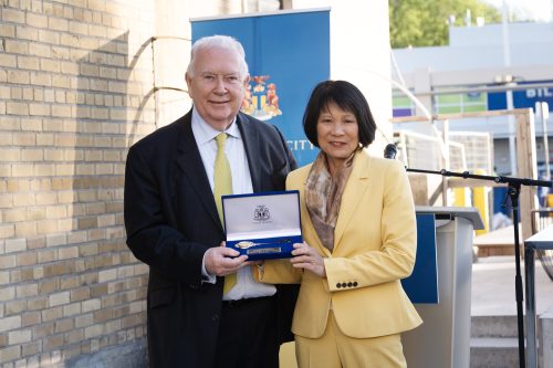 Two people holding a velvet box with the Key to the City