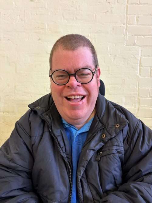 Headshot photography of a man with glasses wearing navy blue jacket