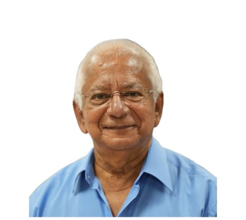 Headshot photograph of elderly man wearing blue button up collar shirt.