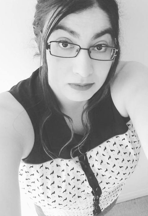 Black and white headshot photo of woman wearing pattern top.