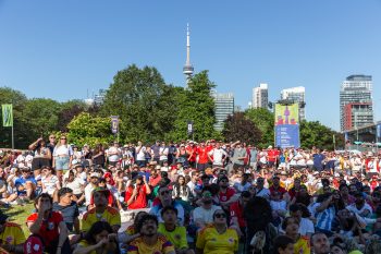 large crowd of fans enjoying themselves at FIFA Fan Festival, CN Tower in the background