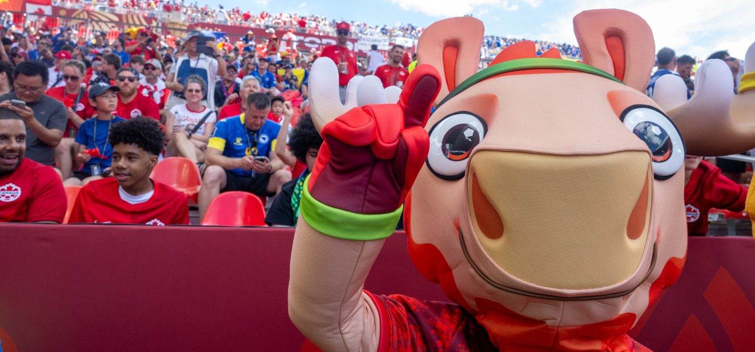 Moose mascot in front of audience in stadium seating